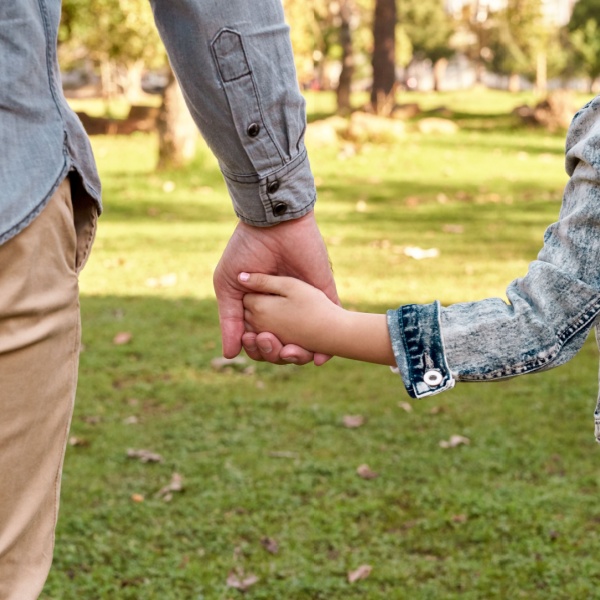 Parent and child holding hands.