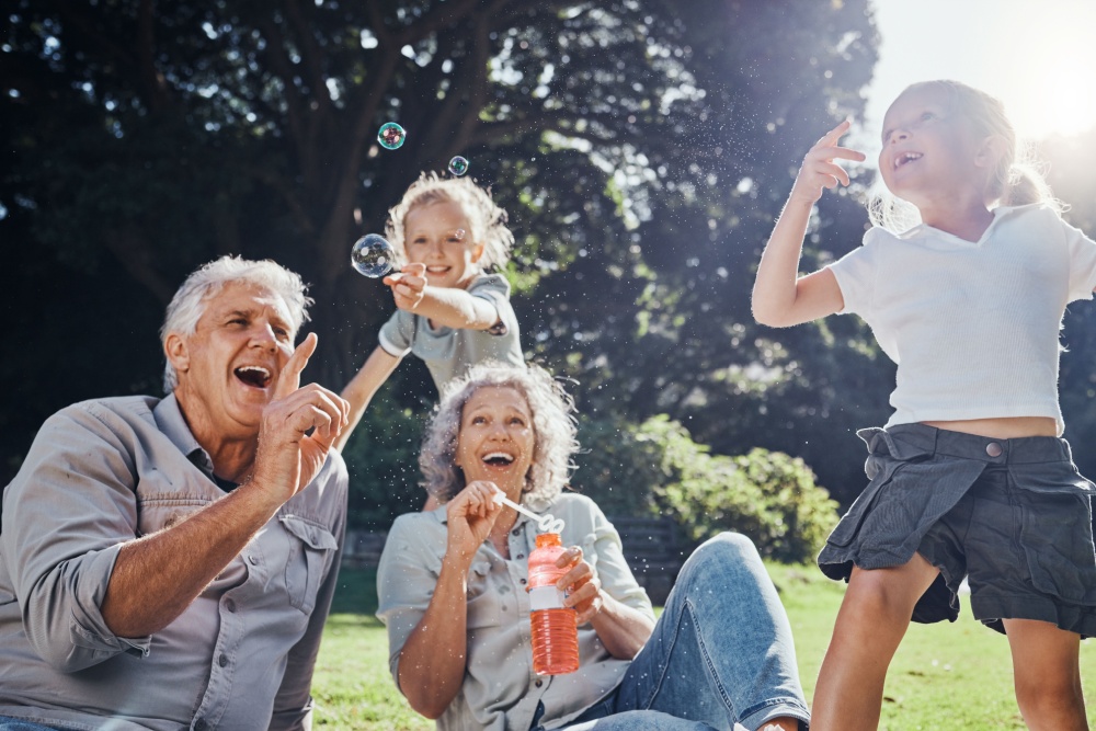 Grandparents blowing bubbles with their grandchildren.