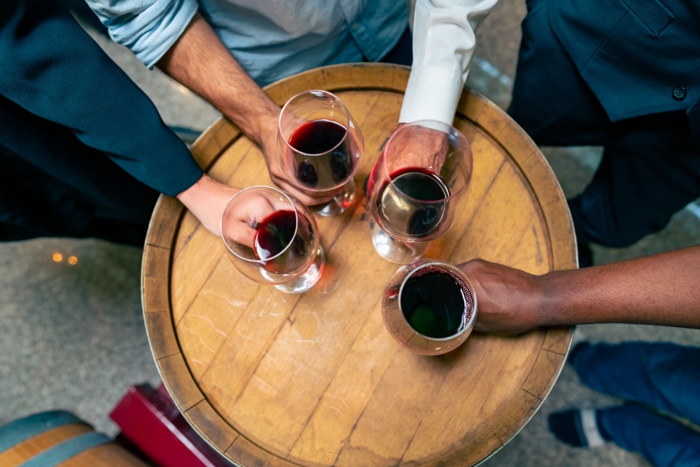 A group of people holding glasses of red wine.