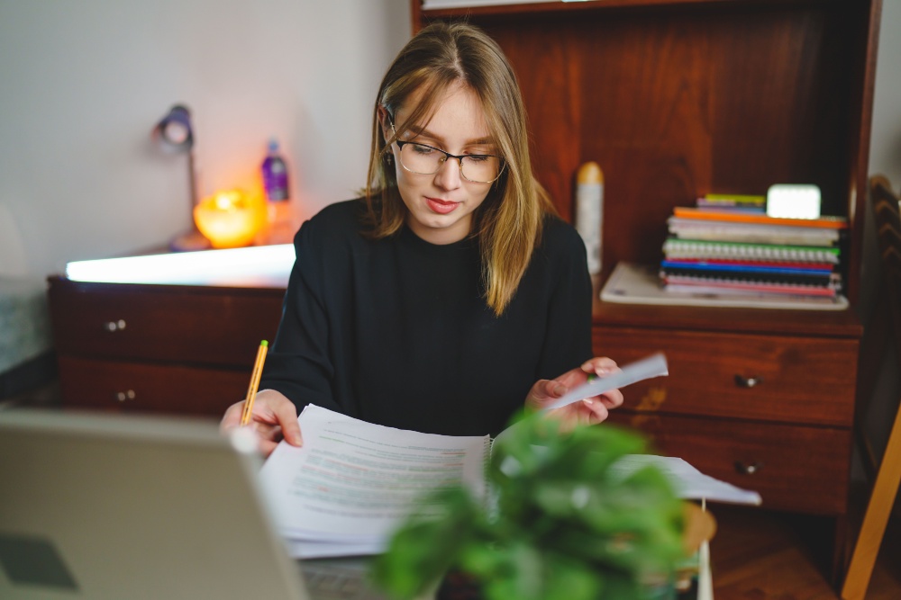 A young woman writing in a notebook.