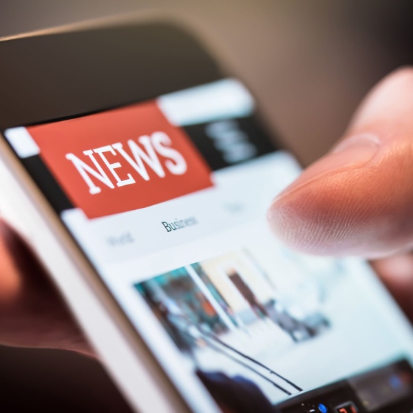 A person using a smartphone to read the news.