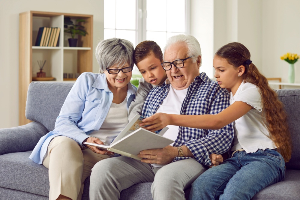 Grandparents looking at a photo album with their grandchildren.