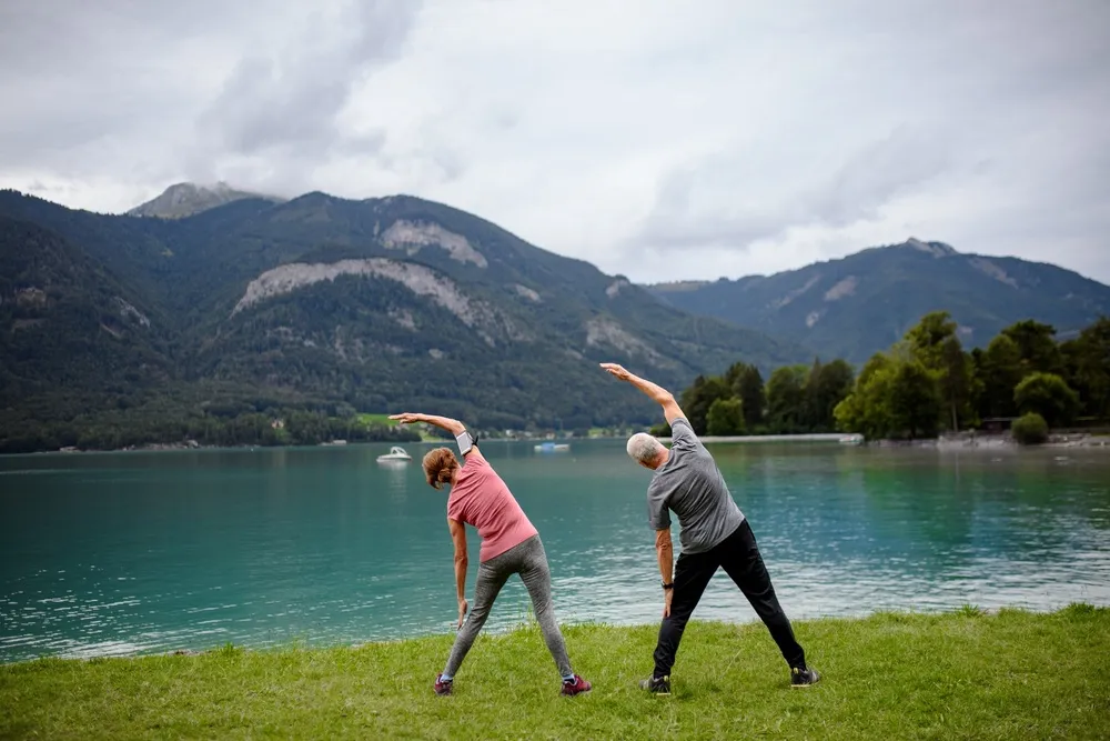 Couple doing tai chi by a lake